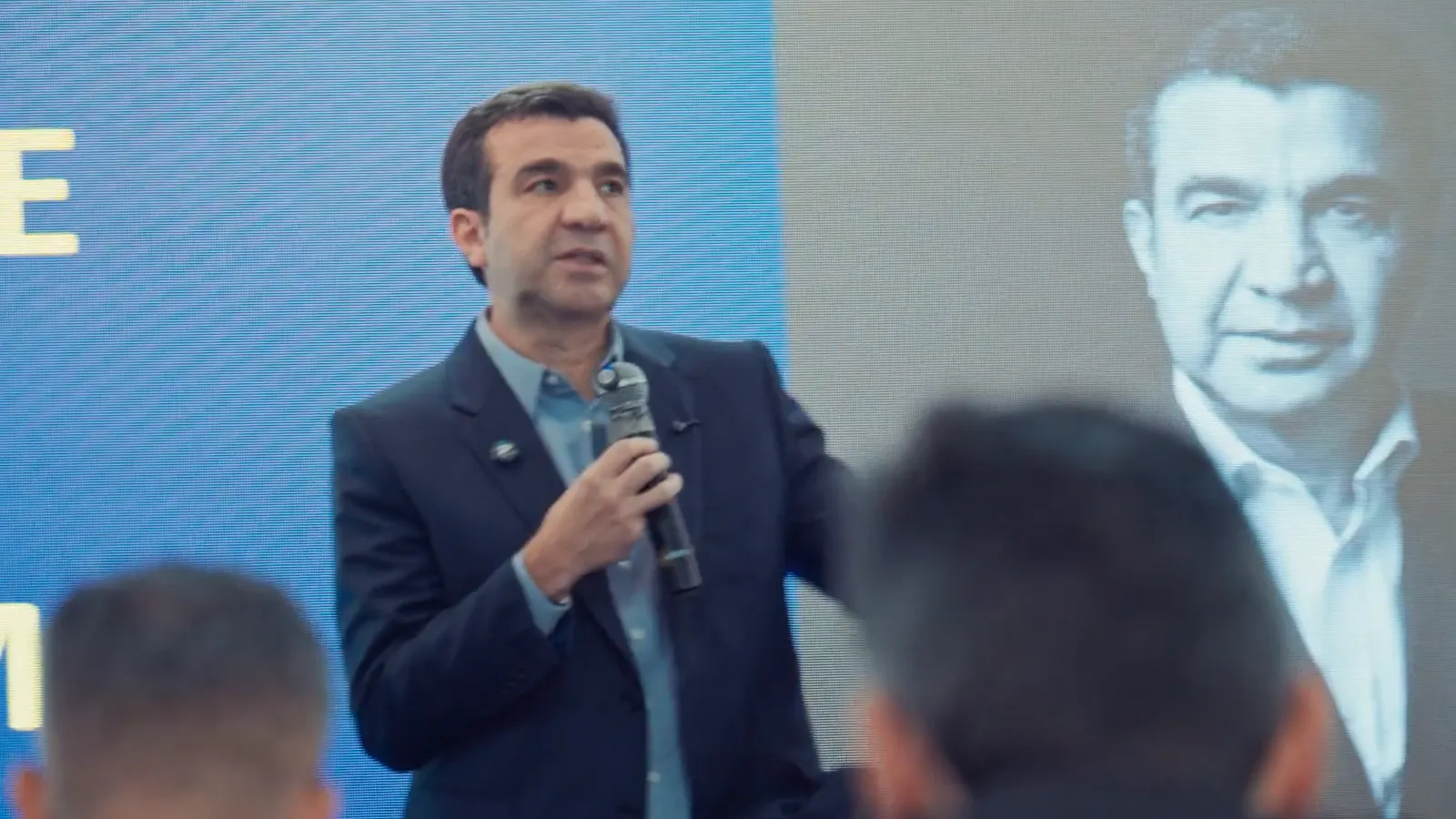 Palestrante com microfone durante um evento do Grupo IFT